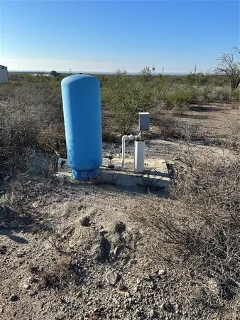 a view of a dry yard with wooden fence