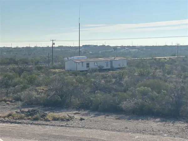 a view of a dry yard with wooden fence