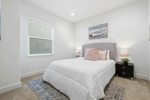 a bedroom with a bed and a painting on the wall