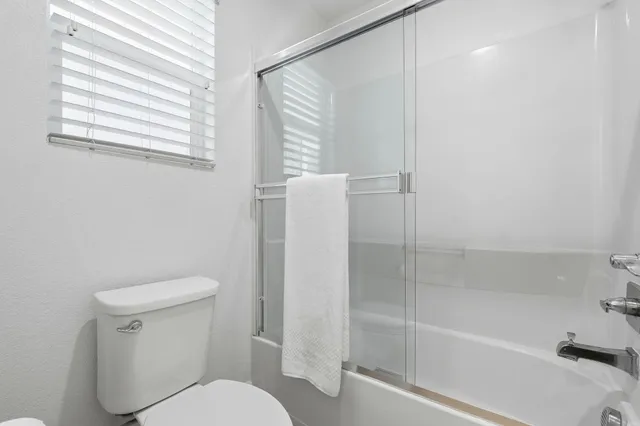 a white toilet sitting next to a bath tub
