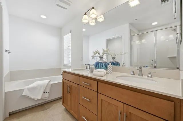 a bathroom with a double vanity sink tub and a mirror