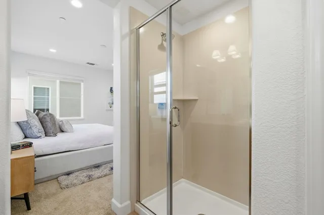 a bathroom with a tub shower and mirror