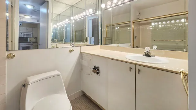 a bathroom with a sink a toilet a mirror and shower