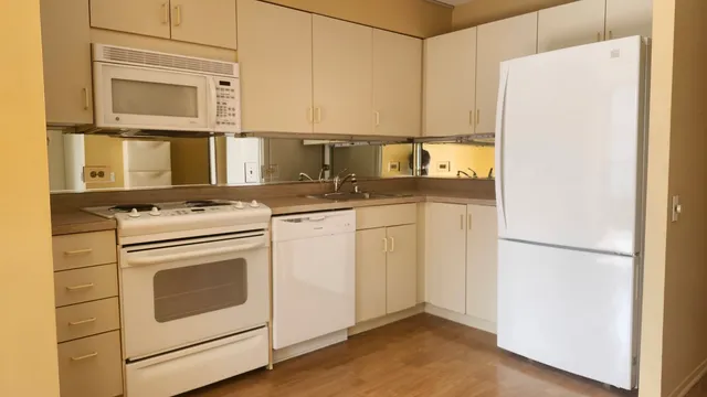 a white refrigerator freezer and a stove sitting inside of a kitchen