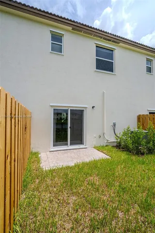 a view of a backyard with plants and large tree