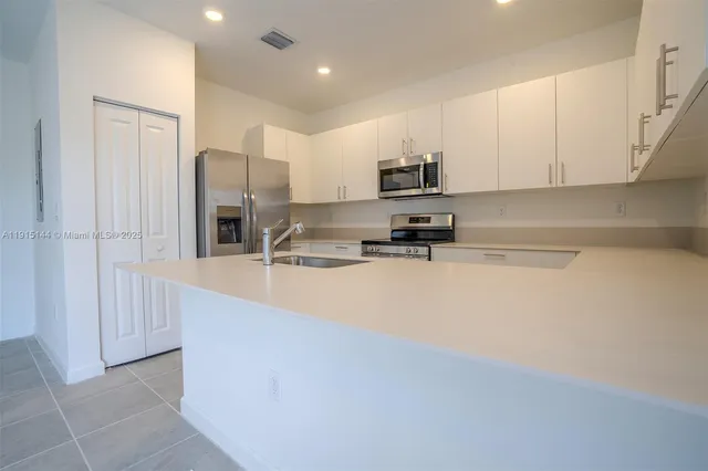 a kitchen with stainless steel appliances a refrigerator sink and cabinets