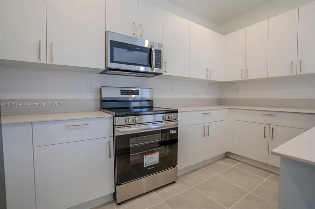 a kitchen with cabinets stainless steel appliances and a sink