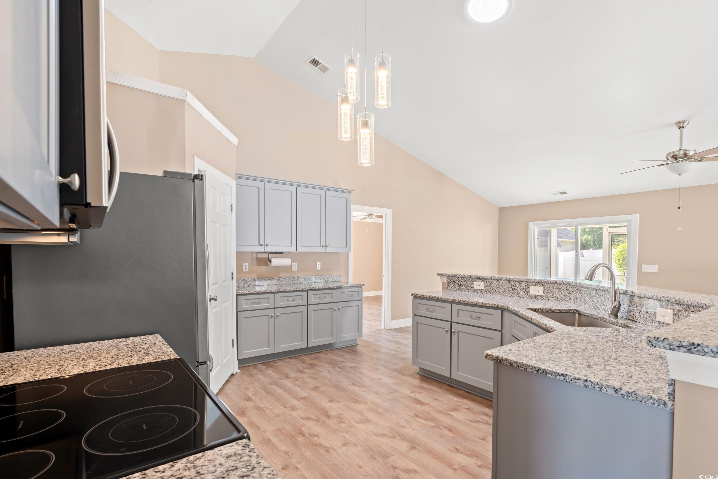 708 Alexis Drive Longs, SC 29568 - Photo 10 of 32 Kitchen featuring gray cabinets, ceiling fan, appliances with stainless steel finishes, light stone counters, and high vaulted ceiling