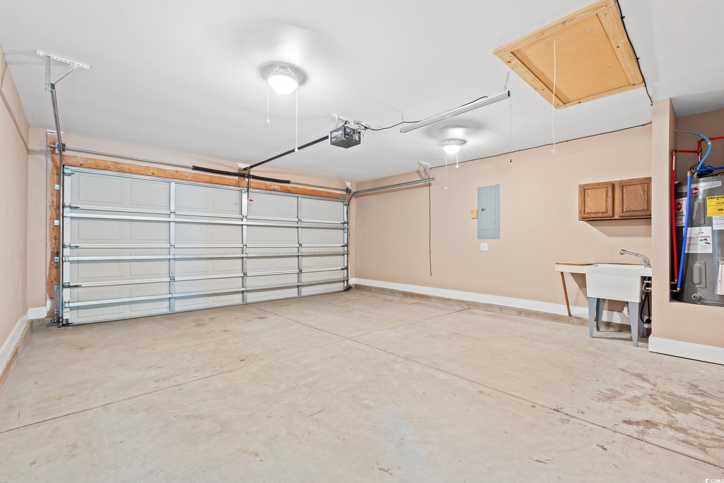 708 Alexis Drive Longs, SC 29568 - Photo 23 of 32 Garage featuring electric water heater, electric panel, and a garage door opener