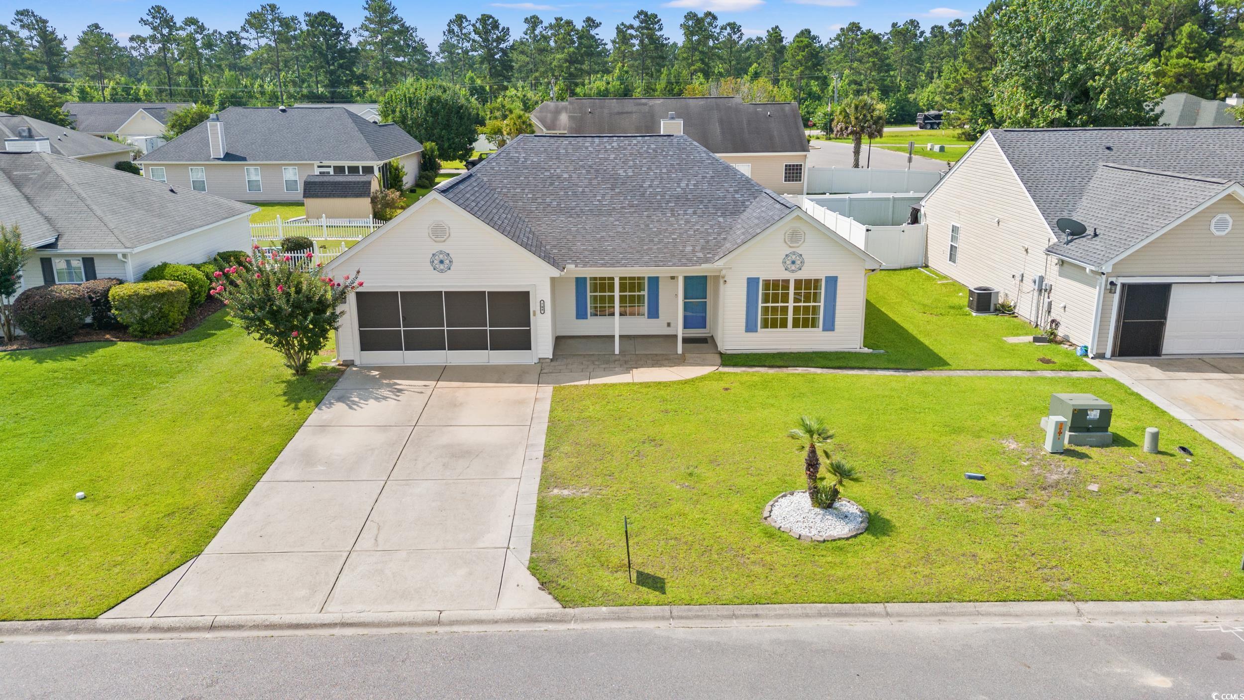 708 Alexis Drive Longs, SC 29568 - Photo 29 of 32 View of front facade with concrete driveway, roof with shingles, an attached garage, a front yard, and a residential view
