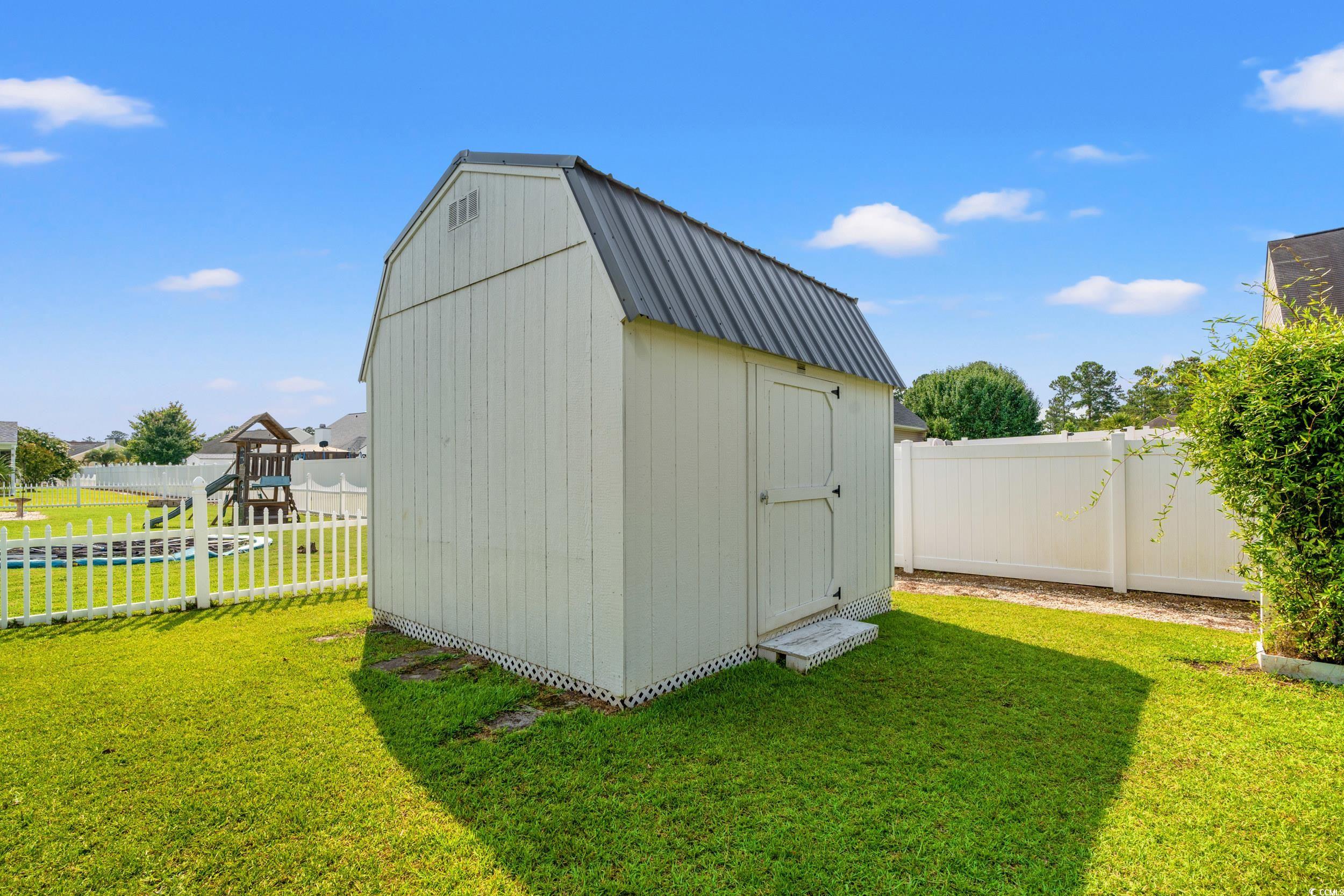 708 Alexis Drive Longs, SC 29568 - Photo 30 of 32 View of shed featuring a fenced backyard and a playground
