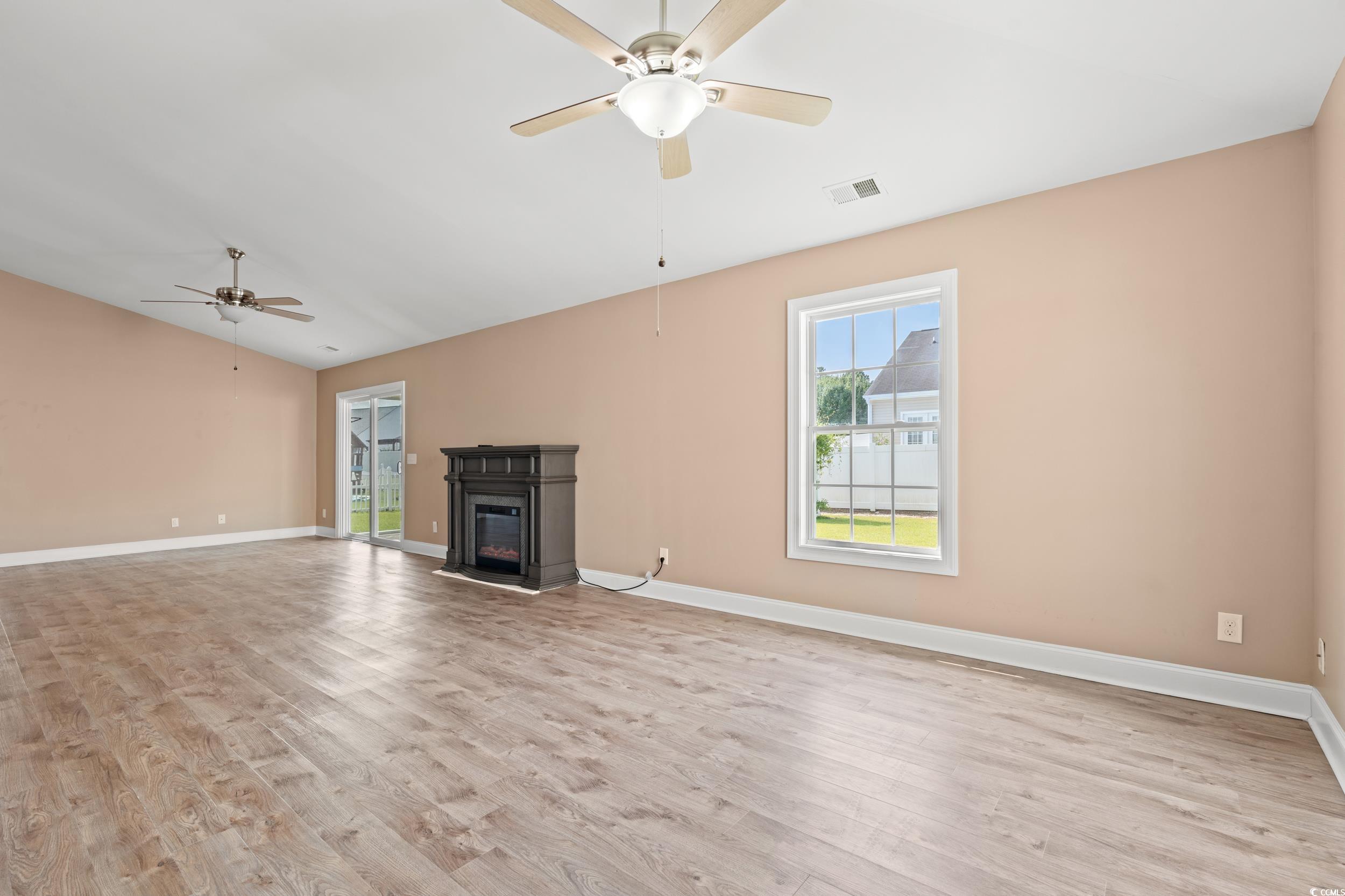 708 Alexis Drive Longs, SC 29568 - Photo 7 of 32 Unfurnished living room with a glass covered fireplace, light wood-style floors, lofted ceiling, and a ceiling fan