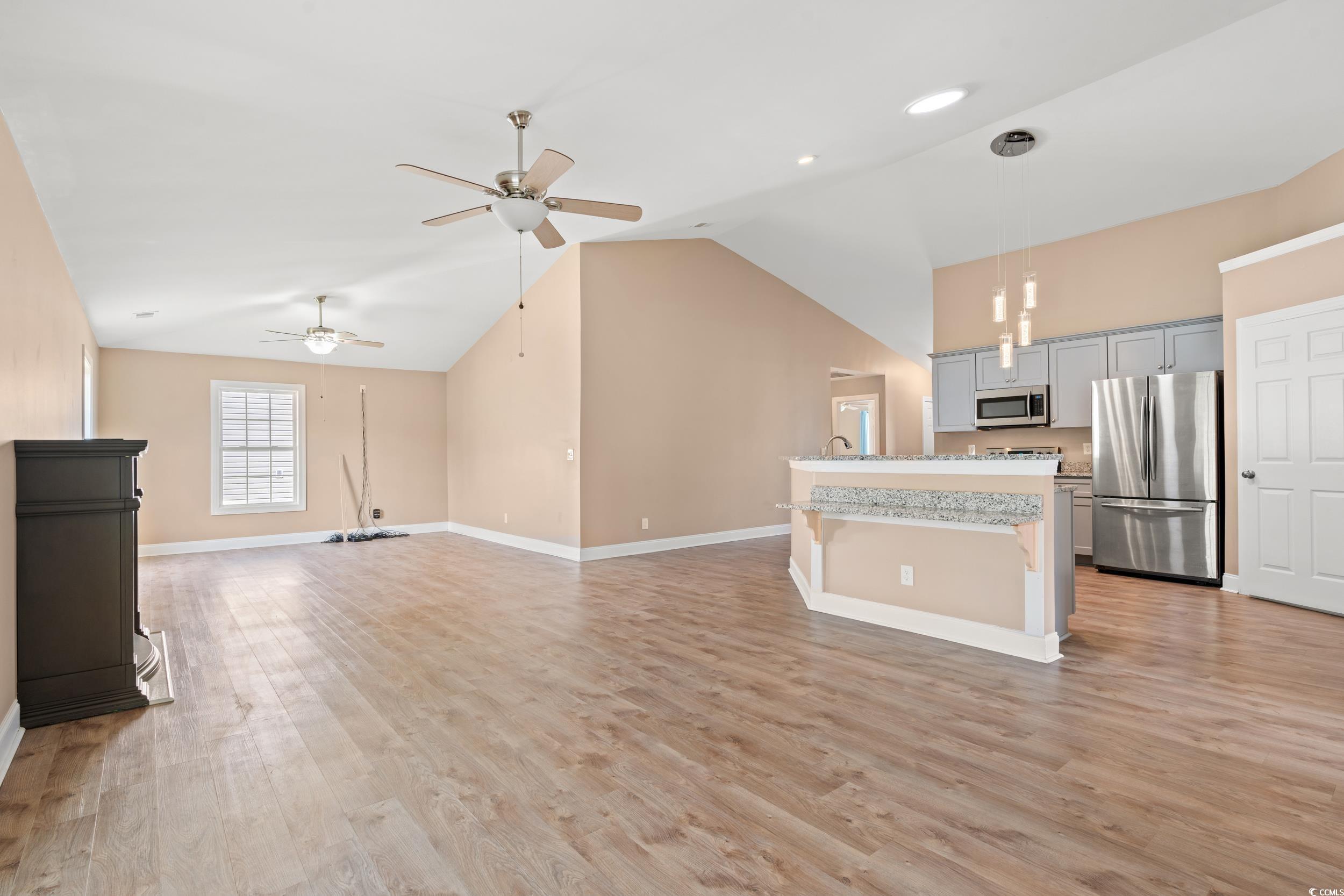 708 Alexis Drive Longs, SC 29568 - Photo 32 of 32 Kitchen with gray cabinetry, a kitchen island with sink, appliances with stainless steel finishes, open floor plan, and decorative light fixtures