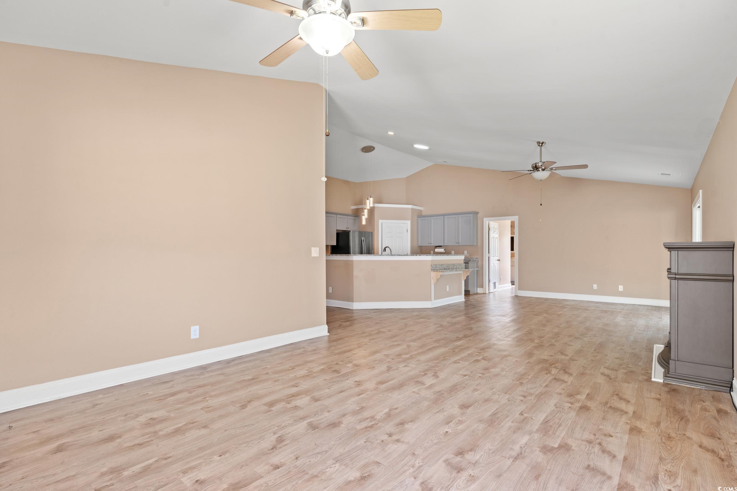 708 Alexis Drive Longs, SC 29568 - Photo 9 of 32 Unfurnished living room featuring lofted ceiling, light wood-type flooring, and a ceiling fan