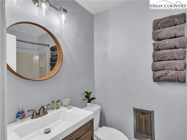a bathroom with a sink mirror and toilet