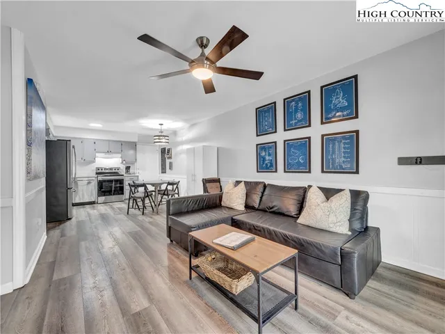 a living room with furniture and kitchen view