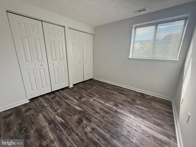 a view of a room with wooden floor and entryway