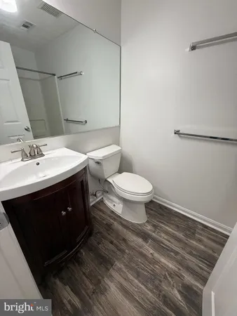 a spacious bathroom with a sink a toilet a mirror and vanity