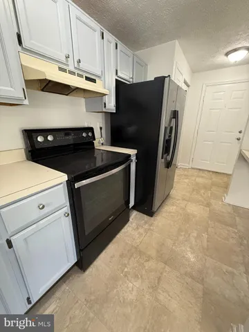 a kitchen with stainless steel appliances a refrigerator a stove a microwave and cabinets