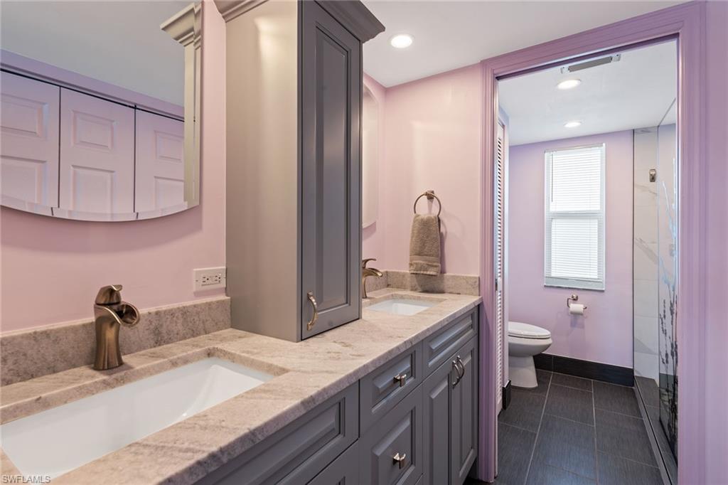 448 Teryl Road, Unit 2341 Naples, FL 34112 - Photo 11 of 32 a bathroom with a granite countertop sink a toilet and a mirror