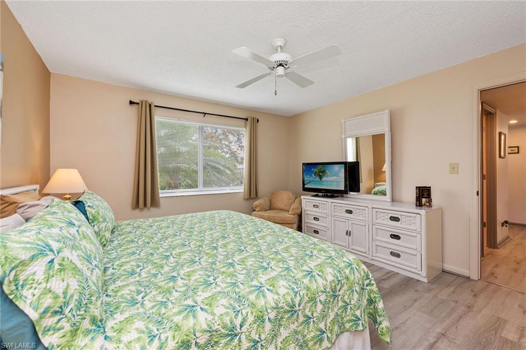 448 Teryl Road, Unit 2341 Naples, FL 34112 - Photo 14 of 32 a spacious bedroom with a large bed and a flat tv screen on dresser