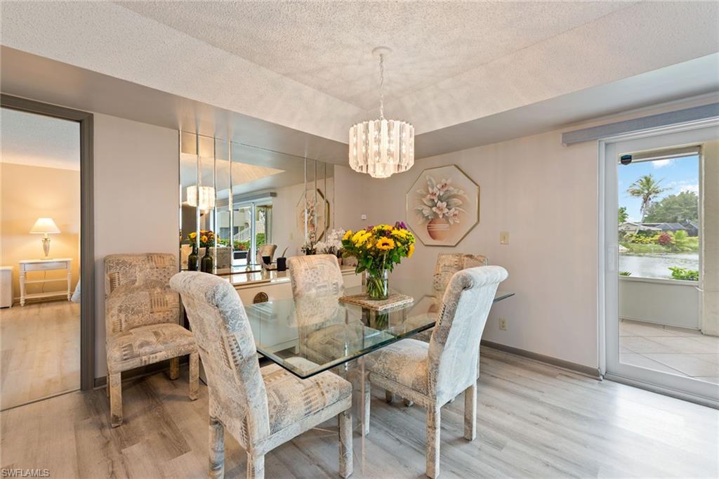 448 Teryl Road, Unit 2341 Naples, FL 34112 - Photo 5 of 32 a view of a dining room with furniture a chandelier and wooden floor