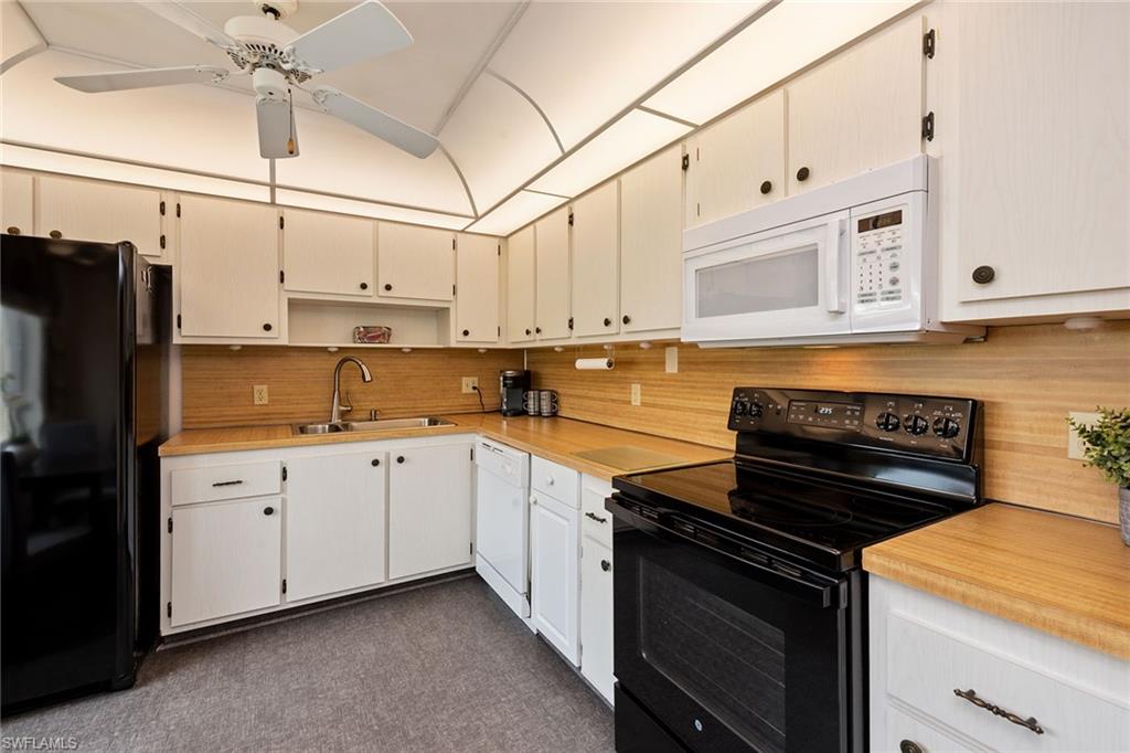 448 Teryl Road, Unit 2341 Naples, FL 34112 - Photo 7 of 32 a kitchen with stainless steel appliances granite countertop a stove and a refrigerator