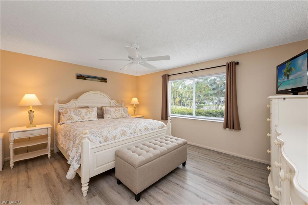 448 Teryl Road, Unit 2341 Naples, FL 34112 - Photo 9 of 32 a bedroom with a bed wooden floor and window