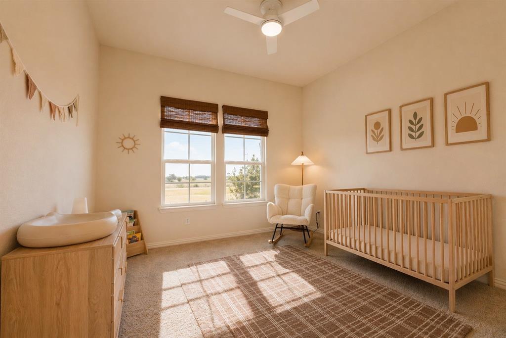 1530 County Road 200 Valley View, TX 76272 - Photo 27 of 34 Bright room featuring double windows with woven wood blinds, a ceiling fan with integrated lighting, and neutral wall tones