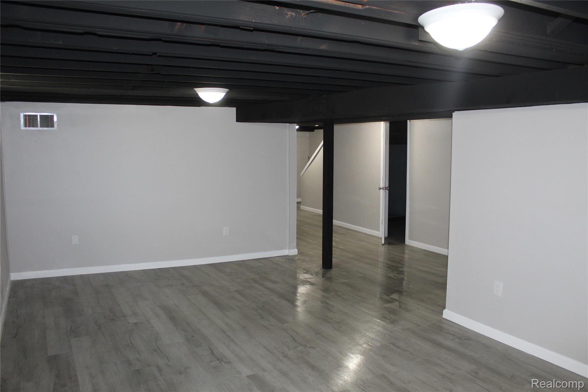 5543 Balfour Road Detroit, MI 48224 - Photo 31 of 54 Finished interior space featuring wood-finish flooring, light grey walls, and a black open-beam ceiling