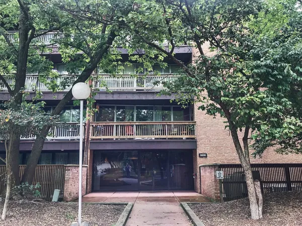 a front view of a house with a tree