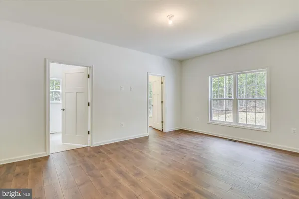 a view of a room with wooden floor and fan