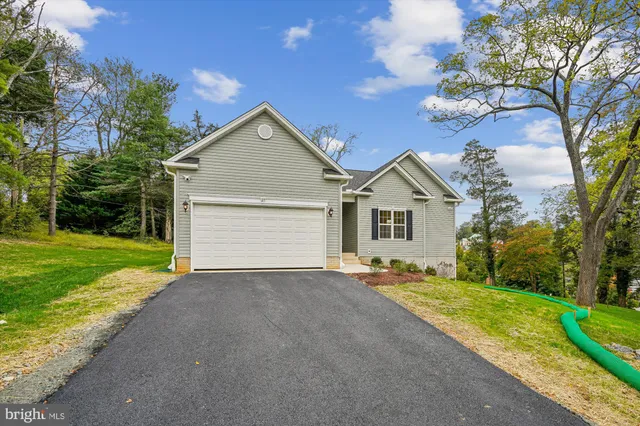 a kitchen with stainless steel appliances granite countertop a stove top oven a sink dishwasher a refrigerator and a fireplace with wooden floor