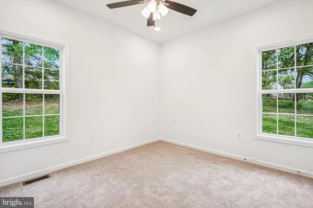 an empty room with closet and fan