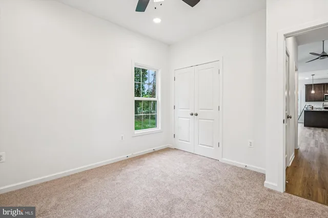 an empty room with a window and a fan