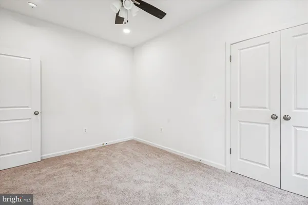 an empty room with closet and fan