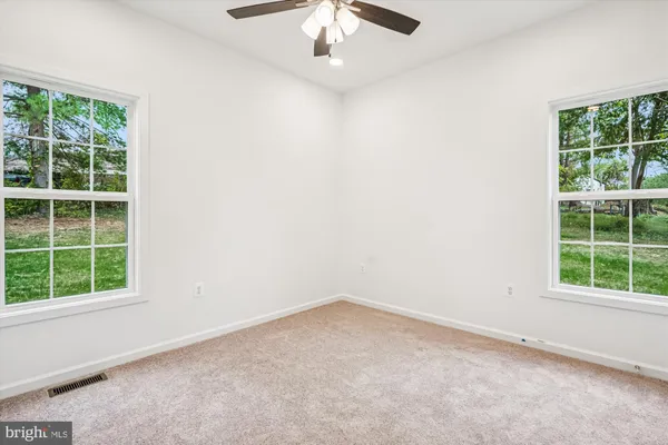 an empty room with a window and a fan