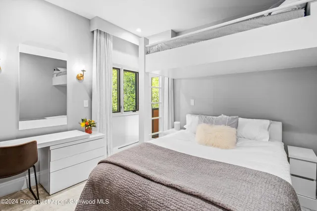 a bedroom with a bed and a large window