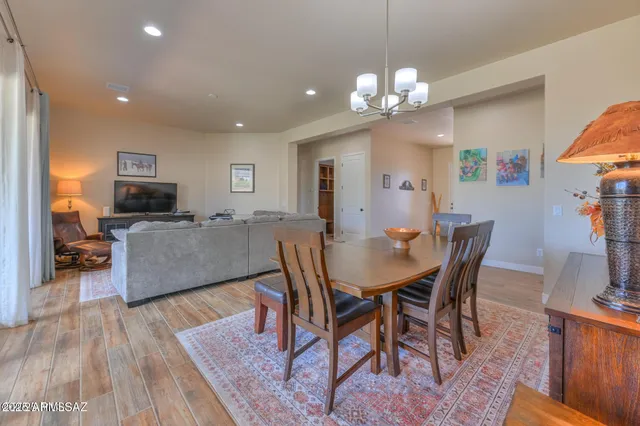 a living room with furniture a dining table and chairs with wooden floor