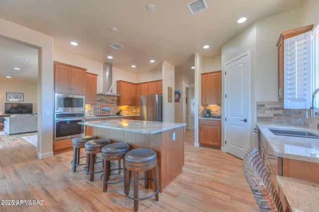 a large kitchen with granite countertop a counter space a sink stainless steel appliances and cabinets