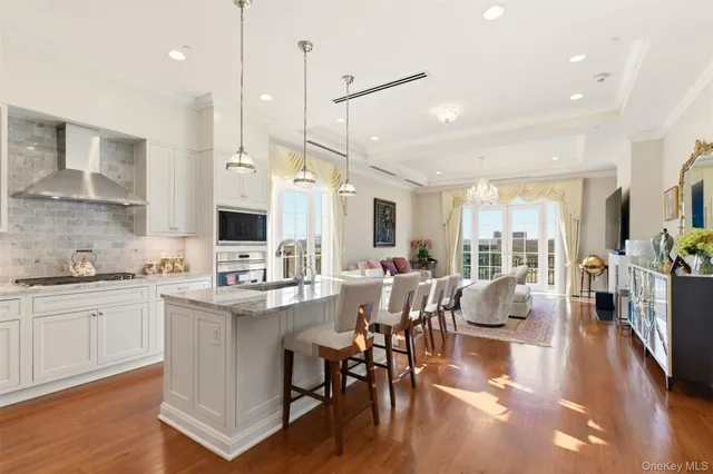 a dining room with stainless steel appliances kitchen island granite countertop a dining table chairs and a refrigerator