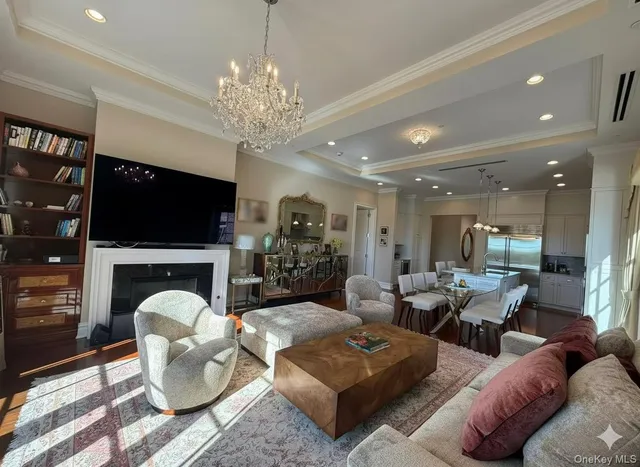 a living room with furniture a chandelier and a fireplace
