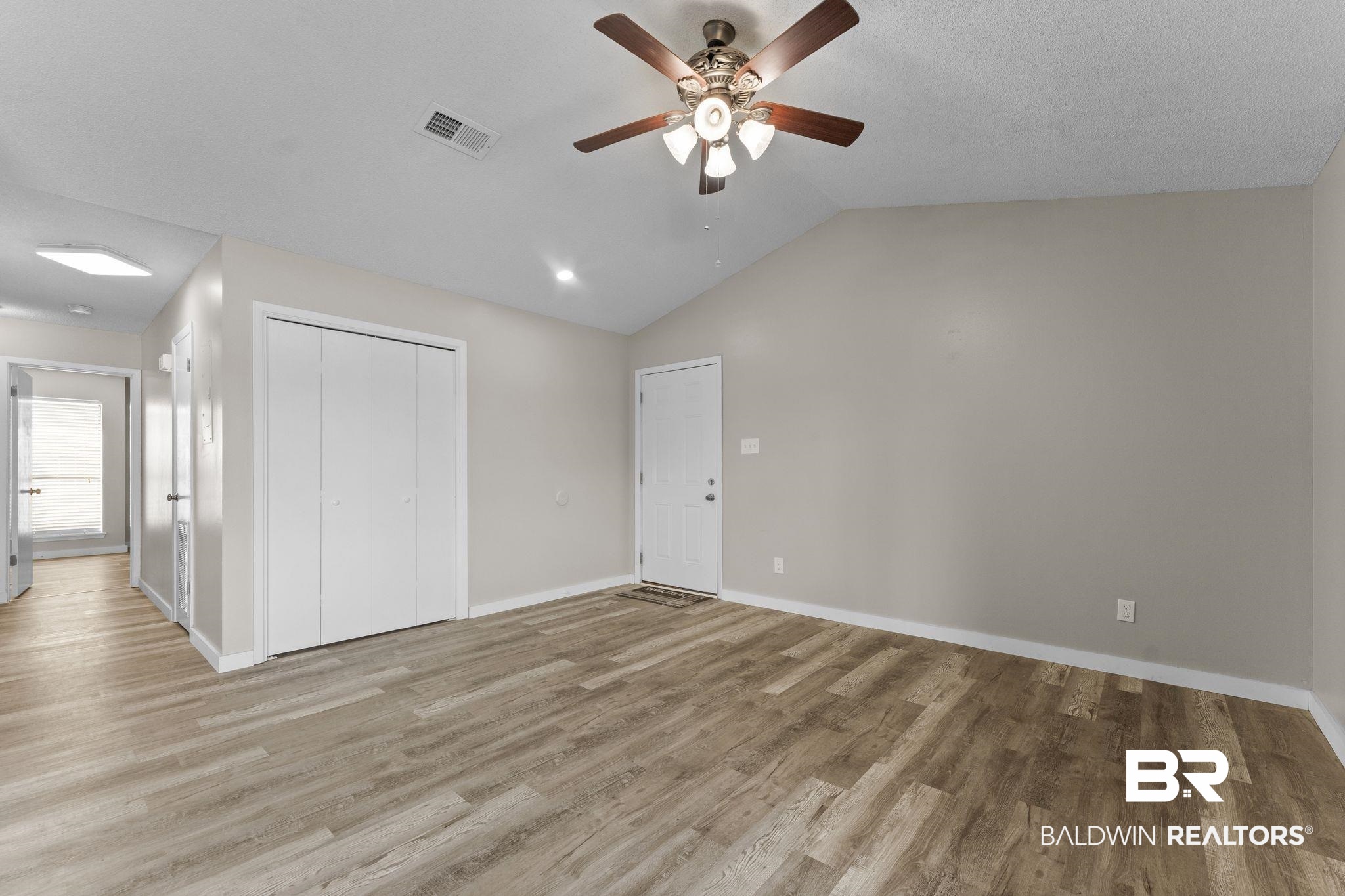128 West Satsuma Avenue, Unit 128 Foley, AL 36535 - Photo 16 of 41 Unfurnished bedroom featuring vaulted ceiling, a ceiling fan, a closet, and light wood-type flooring
