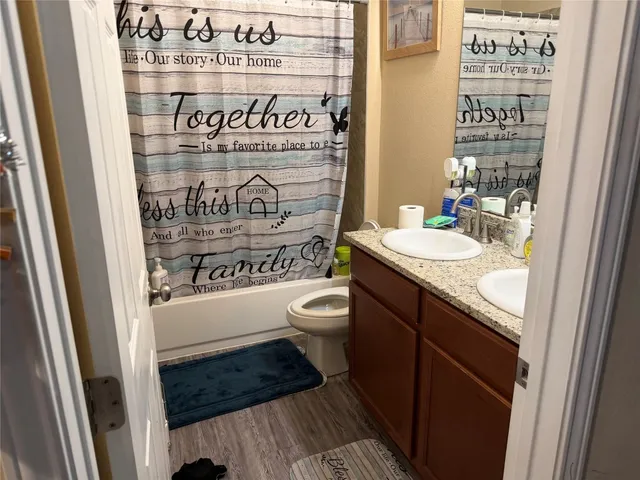 a bathroom with a granite countertop toilet and a sink