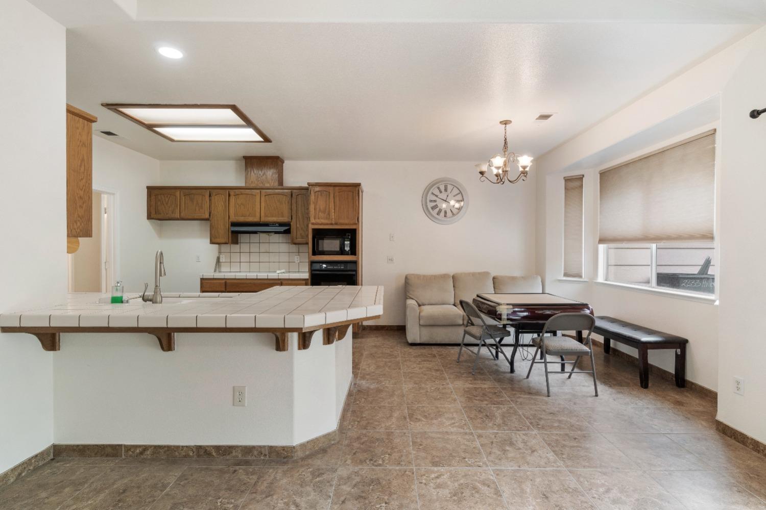 6864 Rodeo Drive Sanger, CA 93657 - Photo 16 of 48 a large room with kitchen island a dining table and chairs