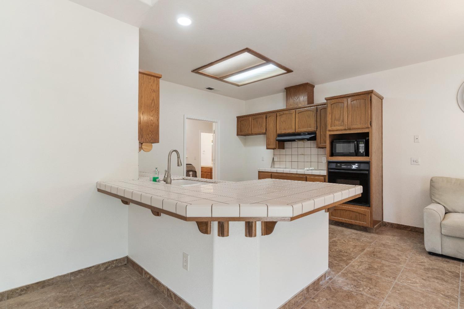 6864 Rodeo Drive Sanger, CA 93657 - Photo 17 of 48 a kitchen with stainless steel appliances granite countertop a sink a stove and a refrigerator