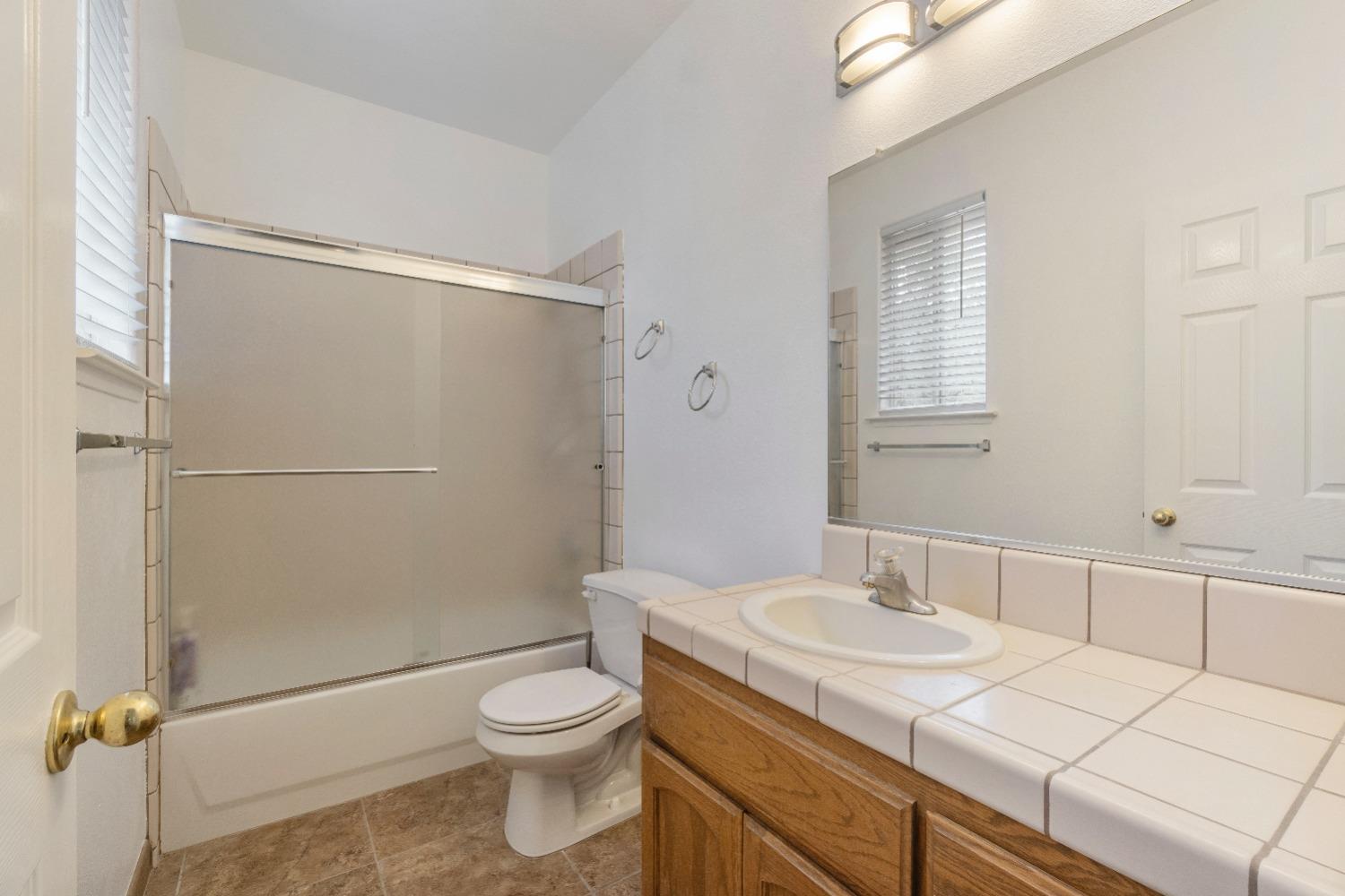 6864 Rodeo Drive Sanger, CA 93657 - Photo 22 of 48 a bathroom with a sink toilet and shower
