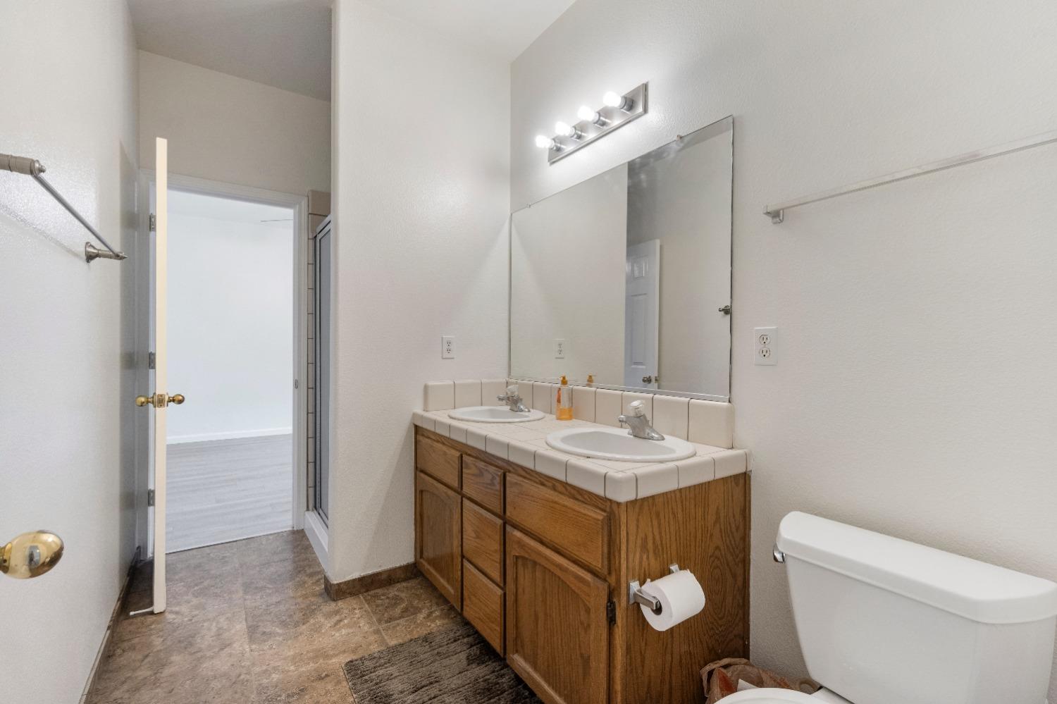 6864 Rodeo Drive Sanger, CA 93657 - Photo 30 of 48 a bathroom with a toilet sink and mirror