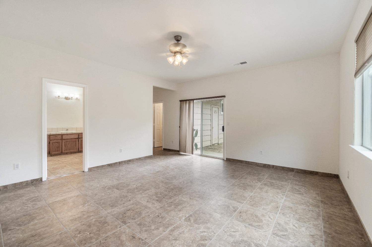 6864 Rodeo Drive Sanger, CA 93657 - Photo 37 of 48 an empty room with chandelier fan and windows