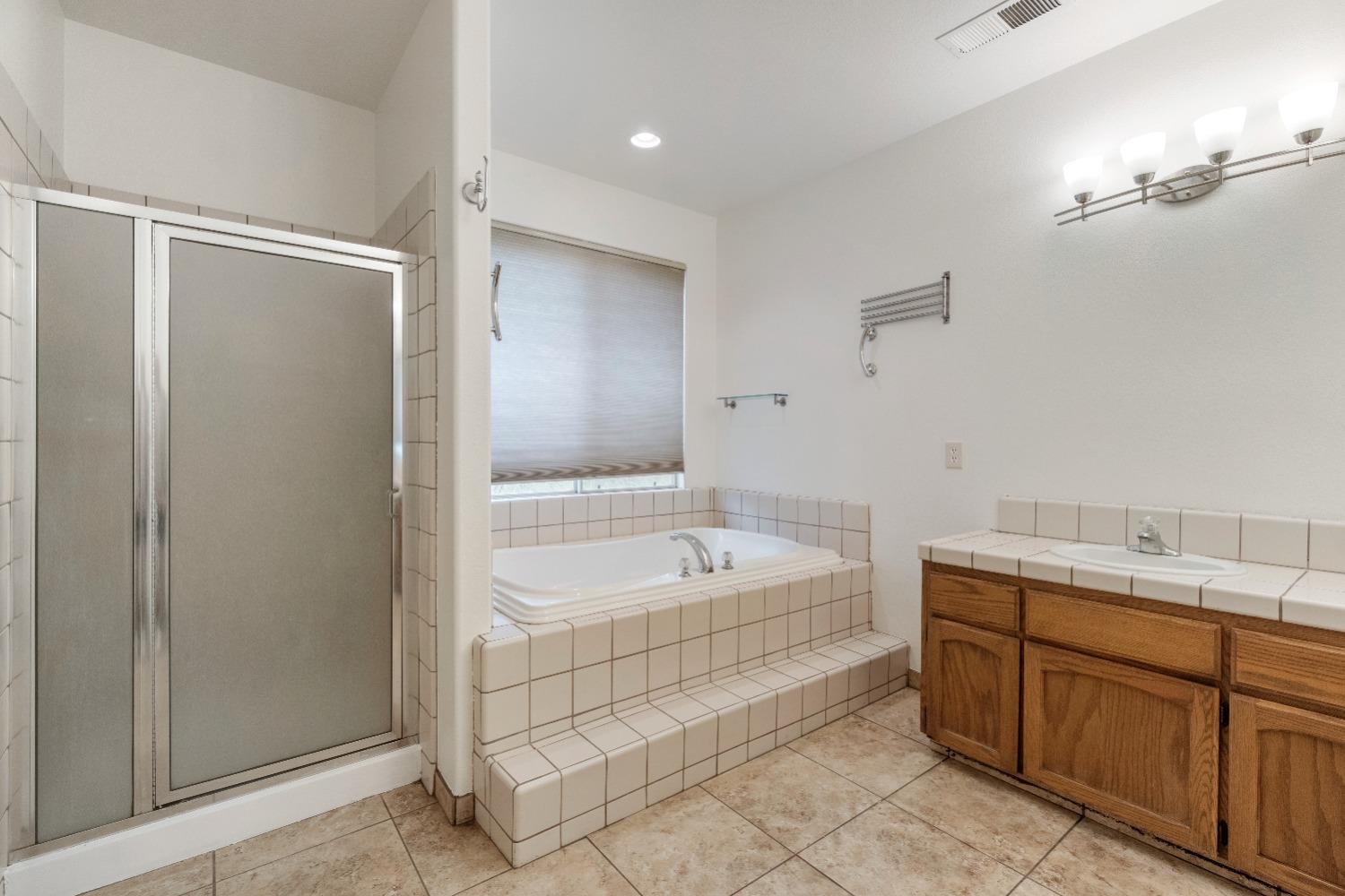 6864 Rodeo Drive Sanger, CA 93657 - Photo 39 of 48 a spacious bathroom with a tub sink and mirror